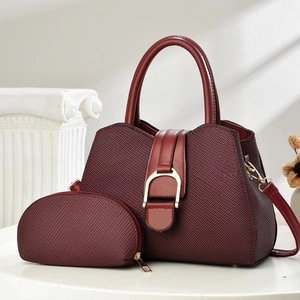 Detailed close-up of wine red hobo bag set with gold hardware on a display stand