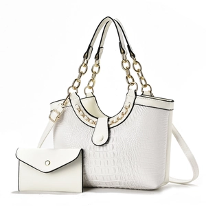 Macro shot of white crocodile embossed texture on a chic handbag with chain detail
