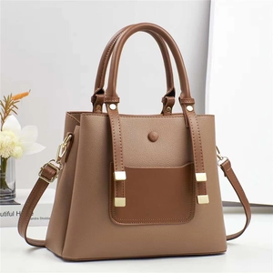 Detailed macro view of the brown lychee grain texture and gold metal buckle on the handbag
