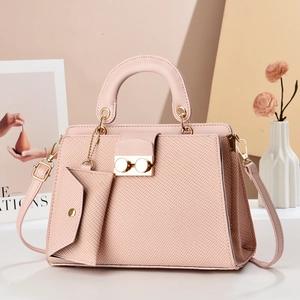 Close-up of pink lizard texture handbag with gold twist lock and mini charm pouch