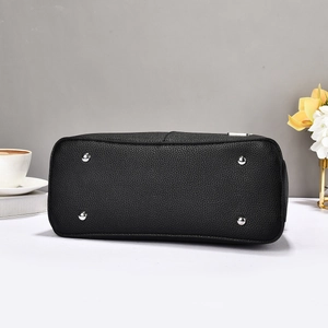 Detail of lychee pattern leather handbag base with protective silver metal studs