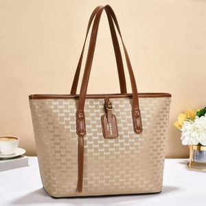 Detail of printed tote bag featuring leather brand tag and vintage letter pattern