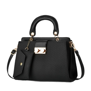Elegant black faux leather handbag with golden hardware and matching envelope pouch charm