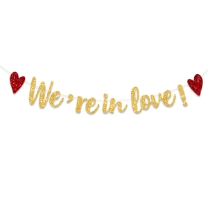 Primer plano de pancarta brillante 'We're in love!' con corazones rojos para bodas