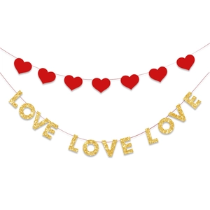 Dettaglio di ghirlande a cuore rosso e scritte LOVE dorate per decorazioni festa