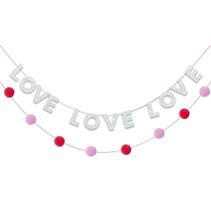 Dettaglio delle lettere LOVE glitterate e pompon morbidi per decorazione festa