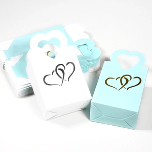 Détails de boîtes cadeaux en kraft avec poignée en cœur et motif de cœurs entrelacés
