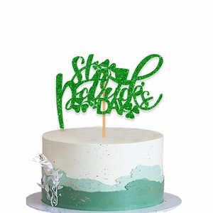 Close-up of green glitter St. Patrick's Day cake topper with clover and shamrock design