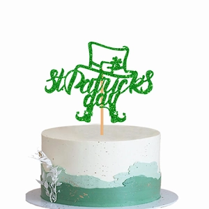 Glittery St. Patrick's Day cake toppers with clover and hat on a white cake