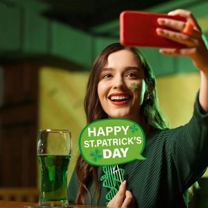 St. Patrick's Day photo booth props including green lucky clover sign and party glasses