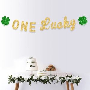 Glittery gold One Lucky banner with green shamrocks for Saint Patrick's Day party decor