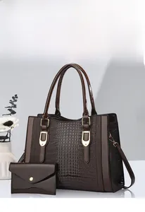 Detail of dark brown faux crocodile tote bag set with golden hardware and matching pouch