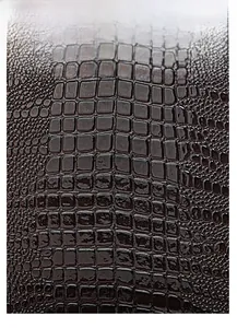 Close-up of deep brown crocodile texture leather with glossy finish on a tote bag