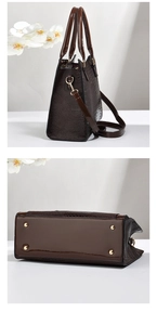 Detail view showing bottom metal studs and glossy brown crocodile texture of tote bag