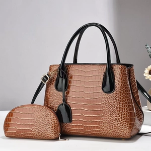 Detail of dark brown croco-embossed tote bag with matching small coin purse and gold hardware
