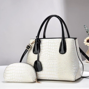 Close-up of white crocodile pattern tote bag with polished golden metal zippers and hardware