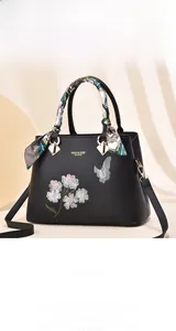 Detail of floral butterfly embroidery and decorative silk scarf on black tote bag