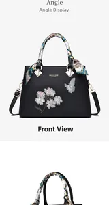 Detail of floral butterfly embroidery and silk scarf handle on black tote bag