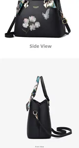 Detail of black handbag featuring floral butterfly embroidery and decorative silk scarf