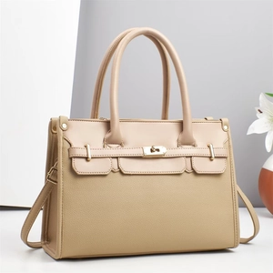 Detail of lychee pattern leather tote bag with golden twist lock and adjustable strap