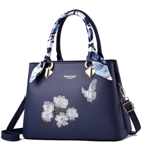 Dark blue leather handbag with floral butterfly embroidery and a stylish silk scarf handle