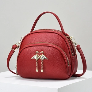 Red multi-compartment crossbody bag with flamingo jewel buckle and top handle