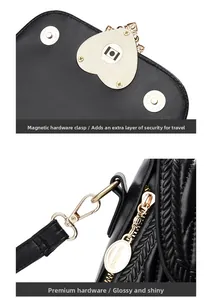 Detail of gold heart magnetic buckle and high-quality hardware on black leather bag