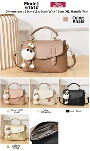 Detail view of lychee texture leather satchel with golden hardware and plush pendant charm