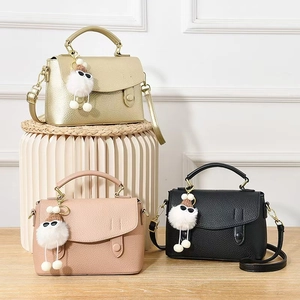 Three leather crossbody bags in gold, pink, and black featuring premium lychee texture