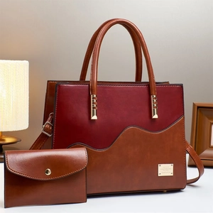 Detail of burgundy and brown tote bag with wave patchwork and golden metal hardware