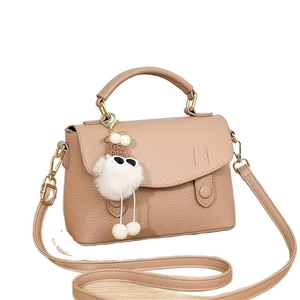 Elegant nude pink leather satchel bag with plush charm and adjustable shoulder strap