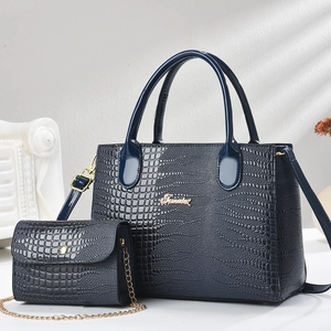 Detail of navy blue croc-embossed patent leather tote and mini chain bag set