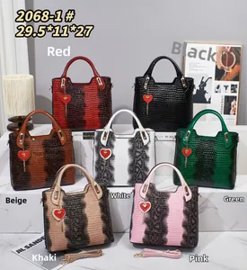 Detailed view of crocodile pattern embossed tote bags in various colors with heart charms