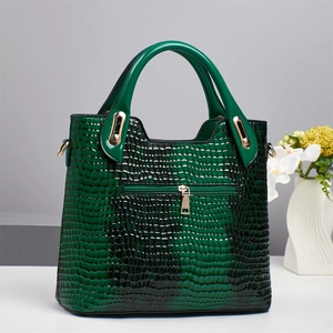 Detail of emerald green crocodile pattern leather bag with elegant gold hardware