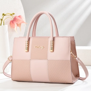 Detail view of pink patchwork handbag with woven texture and gold metal hardware