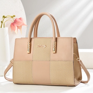 Detail of contrast stitch handbag with smooth beige leather and woven straw texture finish