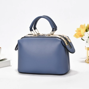 Detailed close-up of dark blue matte leather handbag with elegant gold metal zippers