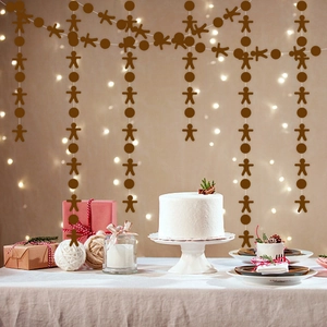 Gingerbread man and circular paper garland hanging for festive party backdrop decoration