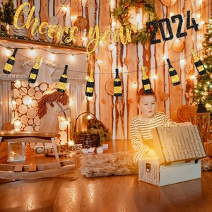 Cheers to 2026 glittery gold and black party banner hanging in a cozy holiday room