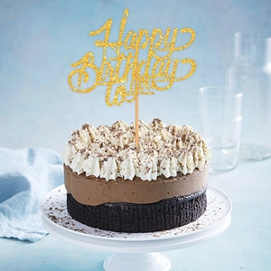 Sparkling gold glitter Happy Birthday cake topper on a chocolate cake with blue background