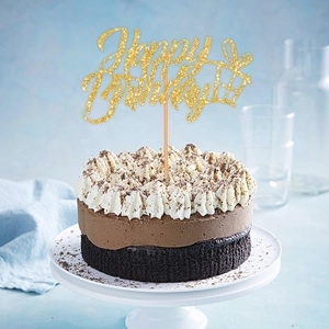 Close-up of glitter gold Happy Birthday cake topper with gift icon on chocolate cake