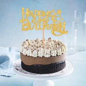 Close-up of golden glitter Happy Birthday cake topper on chocolate mousse dessert