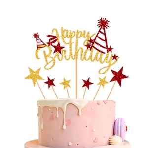 Detail of glitter Happy Birthday cake topper with gold stars and red party hat decor