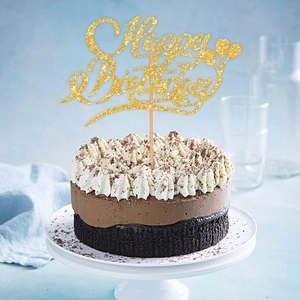Close-up of golden glitter Happy Birthday cake topper with balloon design on a chocolate cake