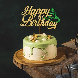 Glittering gold Happy Birthday cake topper with green icon on a matcha green cake