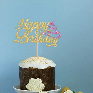 Sparkling gold Happy Birthday cake topper with pink accent on a white frosted cake