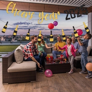 Glittering 2025 New Year party banner set with gold Cheers letters and champagne bottles