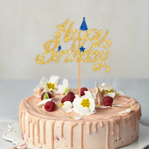 Golden glitter Happy Birthday cake topper with blue star party hat on a fresh berry cake
