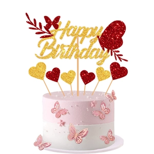 Detail of Happy Birthday cake toppers with gold glitter letters and red butterfly accents