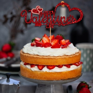 Red glitter Happy Valentine's Day cake topper with heart shapes on strawberry cake